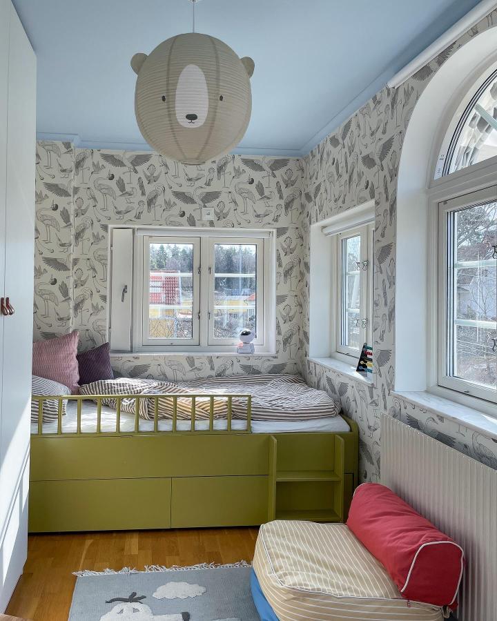 Olive green multifunctional bedroom storage bed with metal railing and built-in ladder by @solhemhuset in a light cozy room.