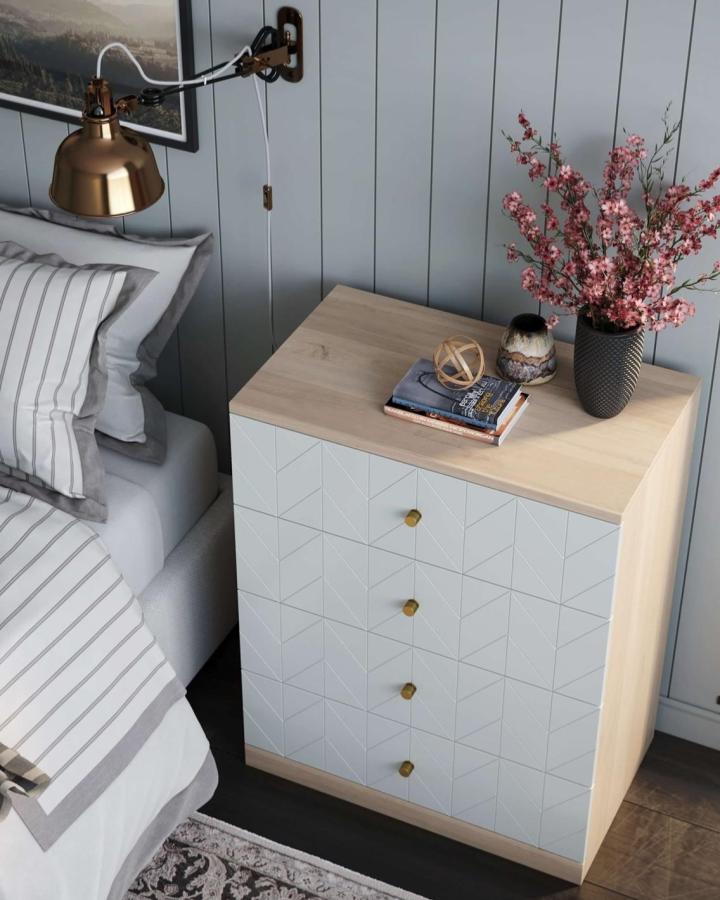 Light grey geometric patterned drawer dresser with brass knobs and light wood top from @norseinteriors in a modern bedroom setting.