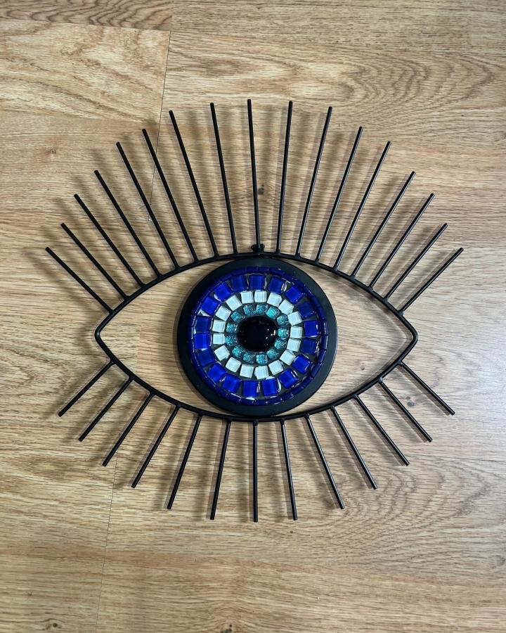 Blue and white glass tile eye mosaic with black metal frame wall art by @gardentileart on wooden floor background. Unique handmade tile design.