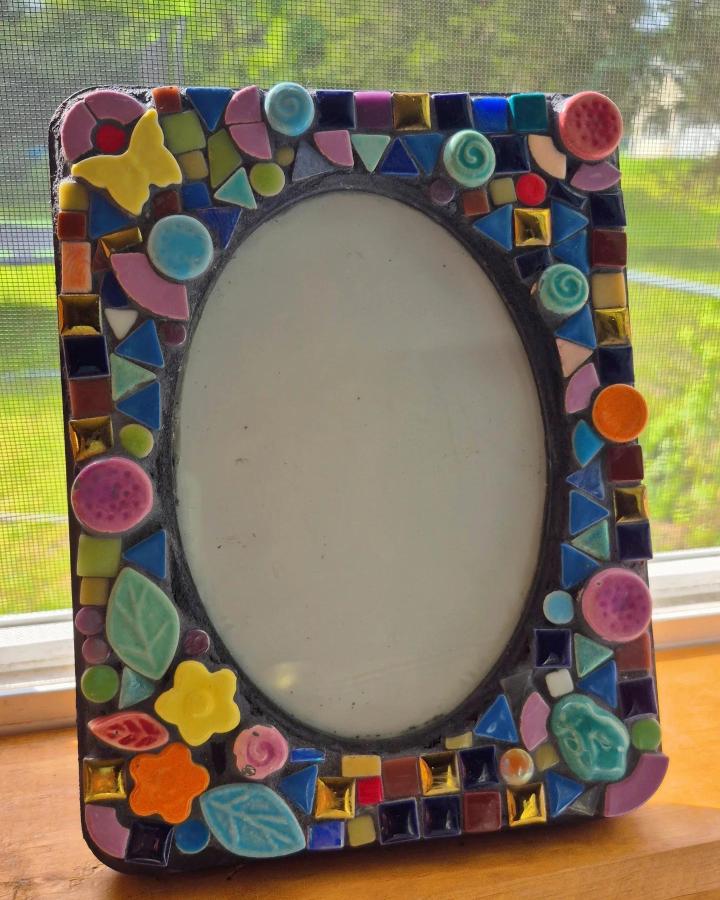 Colorful ceramic and glass tile picture frame from @art_by_shehlamir with playful shapes and floral accents on wood base.