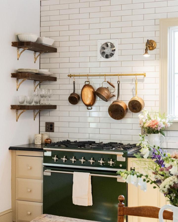 Warm dark wood shelves with brass brackets in kitchen open shelving ideas for your kitchen from @nemotile. Rustic copper pots hang above stove.