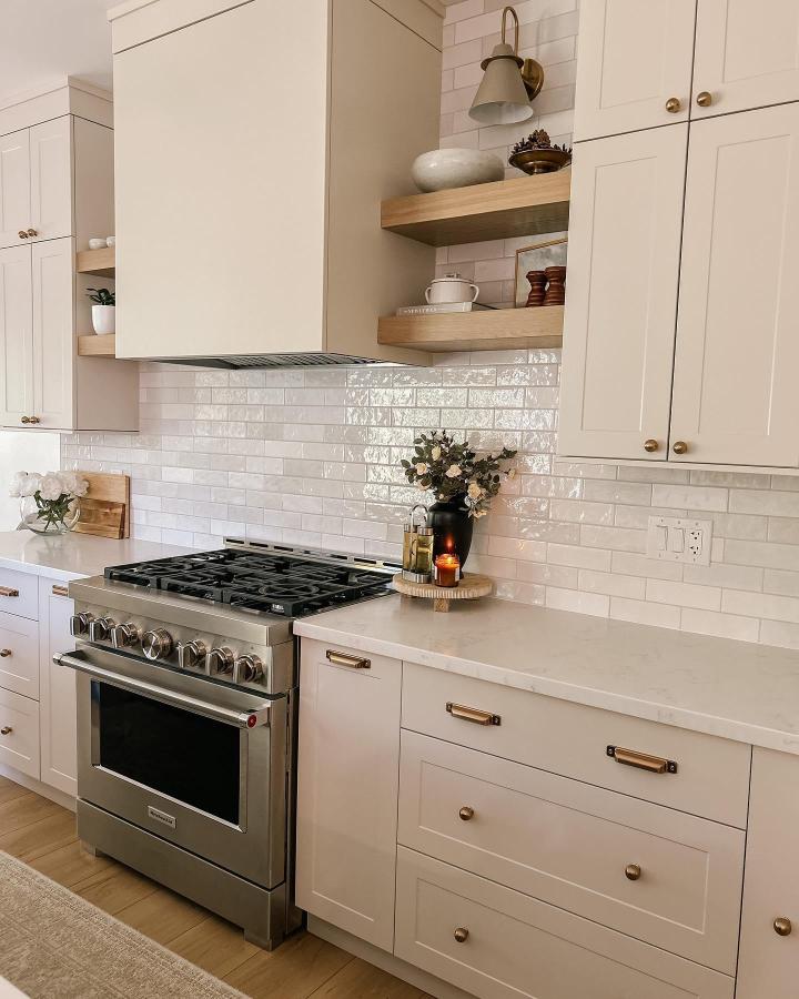 Light oak floating shelves in kitchen with white cabinets and subway tile backsplash from @ourpharmland. Cozy and inviting kitchen decor.