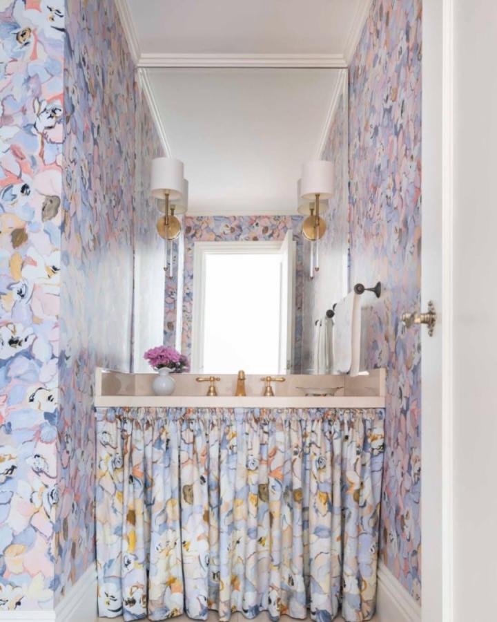 Floral fabric skirt under sink in pastel powder room by @houseofhenryinteriors hiding storage with charm and softness.