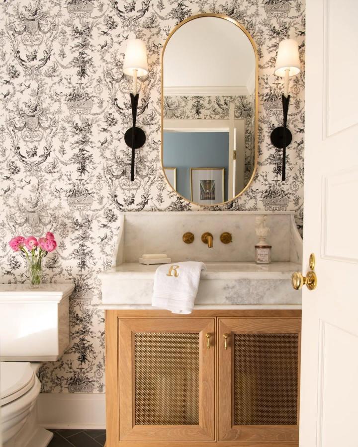 Light wood mesh cabinet vanity from @taylorhartdesign. Stylish air-flow storage with brass hardware and marble countertop.