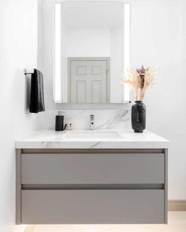 Grey matte floating vanity with marble countertop from @cielo.and.oak featuring powder room storage ideas with integrated drawers and minimalist decor.