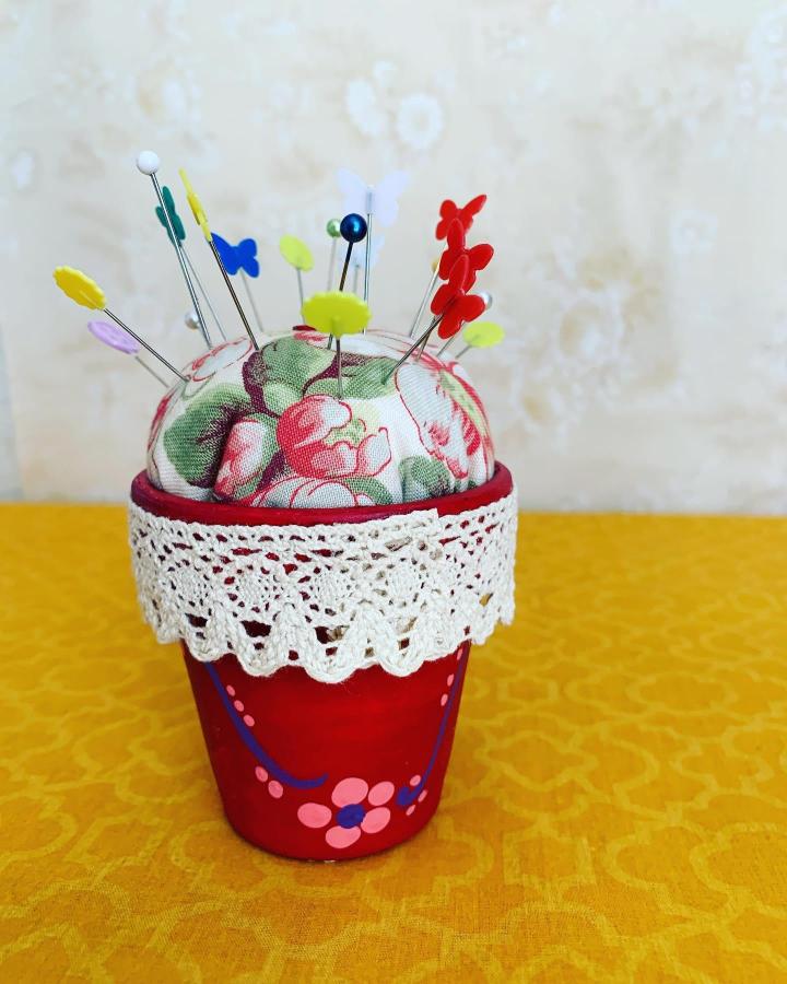 Red hand-painted pincushion pot with lace trim and floral fabric top from @lidiabor2020. Cozy sewing accessory with vintage charm.