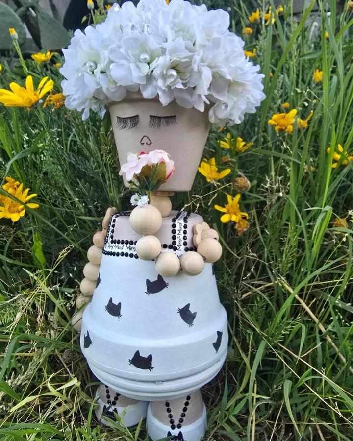Painted whimsical doll with wooden bead limbs and floral headpiece by @le_creature_di_manu crafted from flower pots with cat motifs.