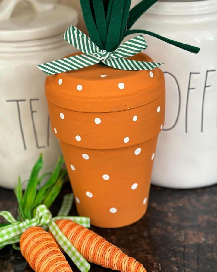 Orange polka dot planter with green felt leaves and striped bow from @house_of_jase. Hand-painted fun spring craft idea.