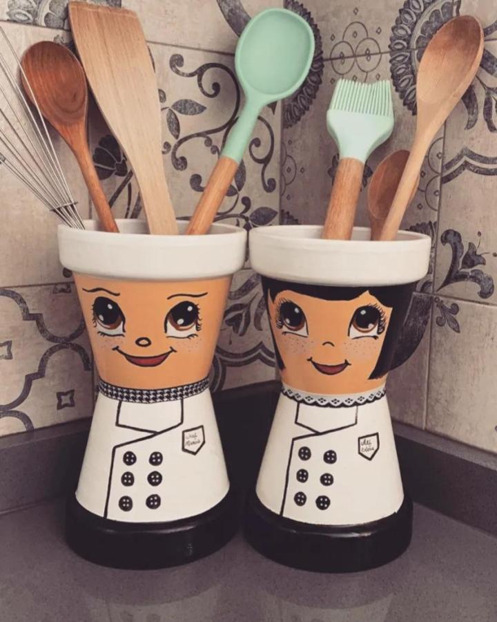Whimsical painted terracotta kitchen holders from @craftycreationsmt featuring cute chef faces and apparel details.