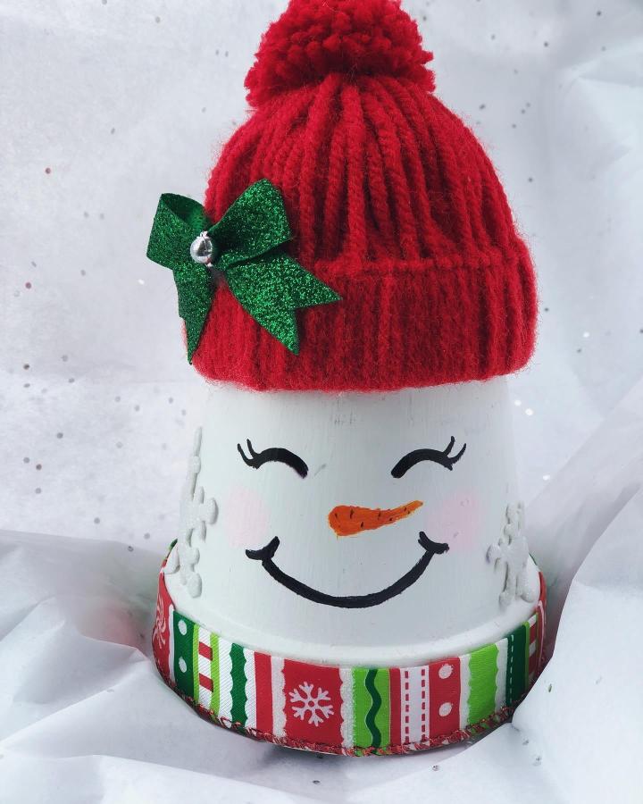 Festive painted snowman container with knit red hat and decorative ribbon from @cupcakelovefuncrafty smiling happily.