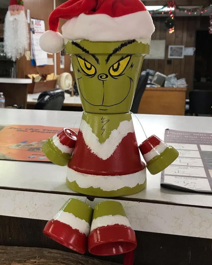 Green and red painted stacked pot figure with a Santa hat and painted face from @gorgeoususedgarbage. Festive handmade holiday planter decoration.