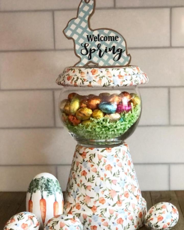 Floral patterned decoupage terracotta pot with Easter-themed decorations and colorful foil eggs from @cathiefilian showcasing a spring craft display.