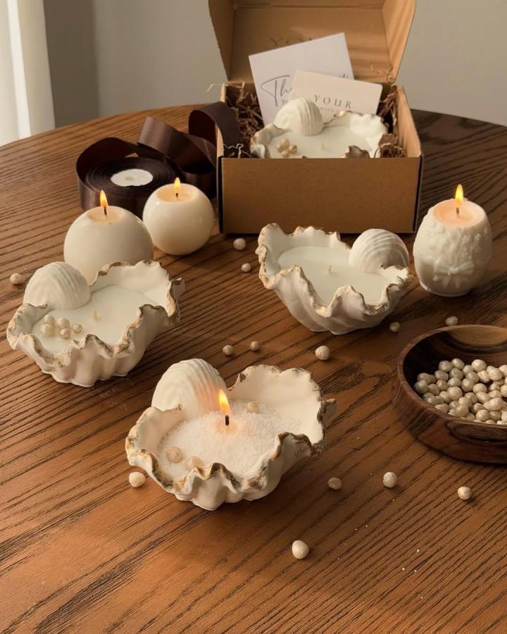 Ivory shell candles from @__yourcandle. Coastal tabletop craft with pearl accents.