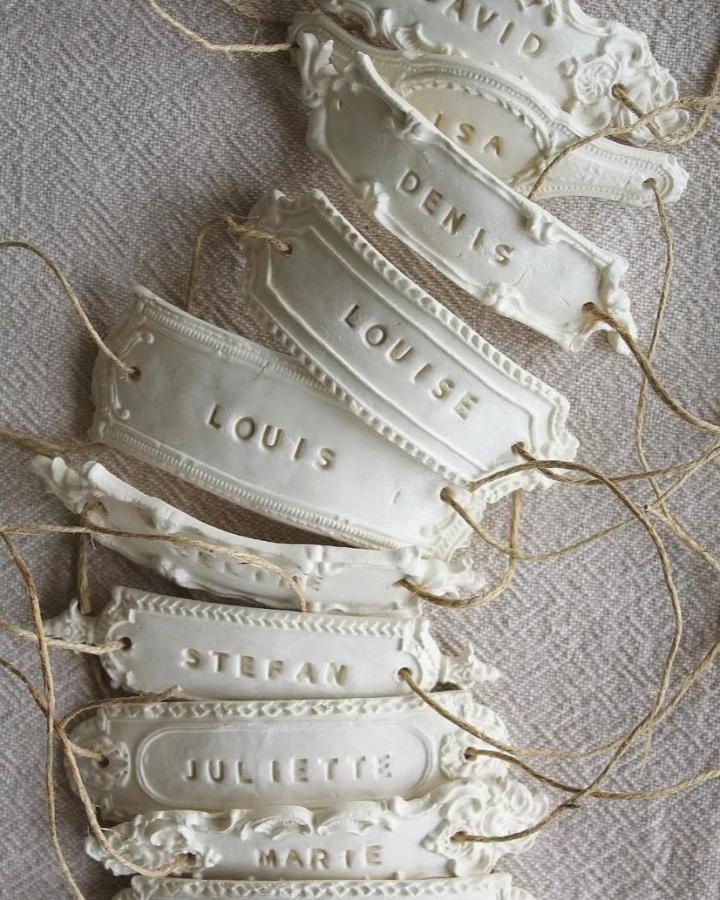 White ornate clay place cards from @weddingchicks. A diy wedding crafts idea with twine and stamped names.