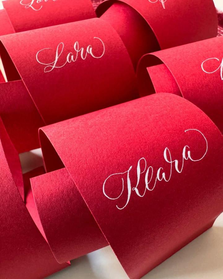 Ruby red paper favor wraps from @nibtique. diy wedding crafts feature white calligraphy names.