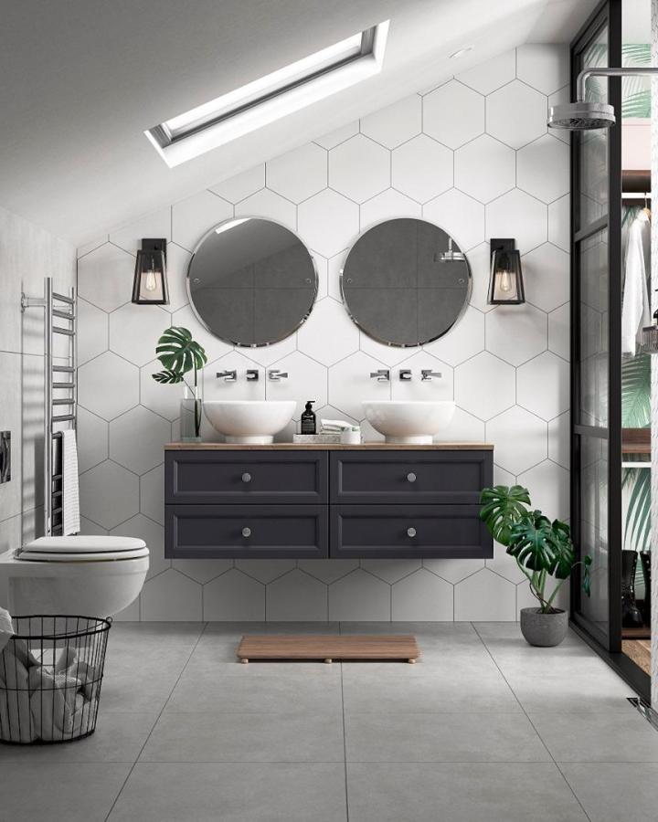 White hexagon-tile double vanity from @heritagebathrooms. Charcoal drawers, round mirrors, vessel basins, and tropical greenery.