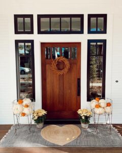 Rustic white-and-orange pumpkin baskets from @darlingiloveit. Symmetrical autumn entryway with mums and a dried wreath.