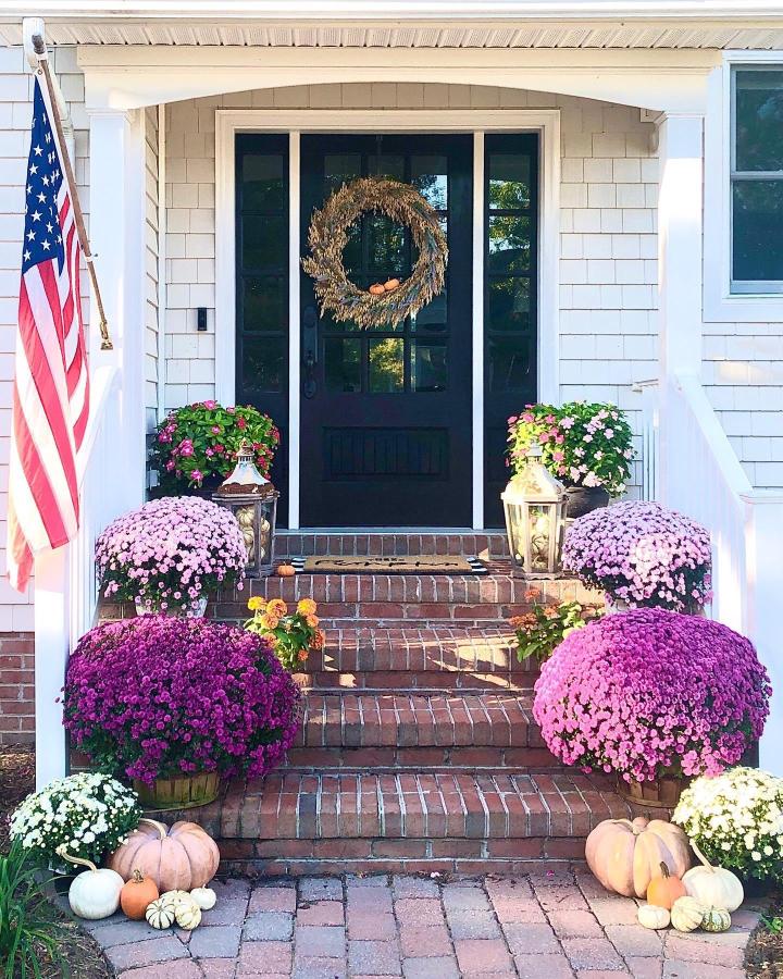 Pink and peach chrysanthemum front steps from @tiffaniatbretonbay. fall front steps decor ideas with pumpkins and wreath.