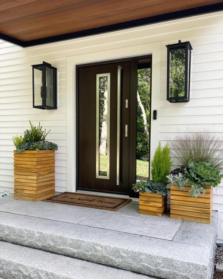 Golden cedar entry planters from @oakandthymeco. Layered grasses, succulents, and silvery foliage create a polished autumn porch display.