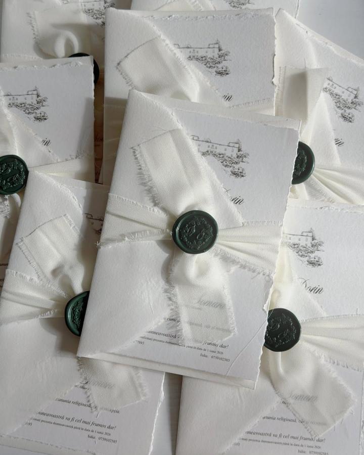 Ivory deckle-edge invitations from @evara_handmade.art__. Handmade wedding invitations ideas with emerald wax seals.