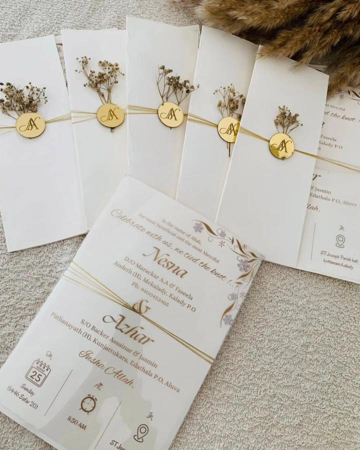 Ivory floral invitation sleeves from @_fasin_art. Pale gold twine and monogram wax seals create an elegant botanical suite.