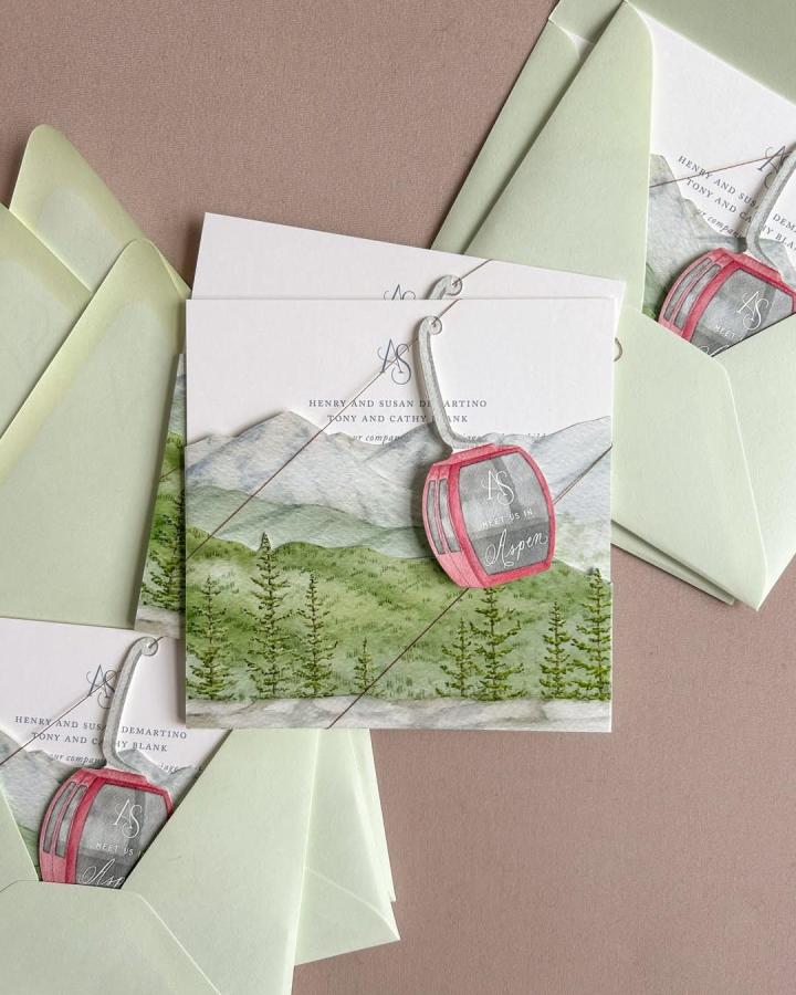 Watercolor mountain wedding invitations from @noraobrienstudio. Pale green envelopes with pink illustrated seal accents.