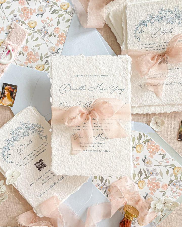 Ivory deckled paper wedding invitations from @kattonepaper. Blush ribbon, botanical details, and floral envelope liners.