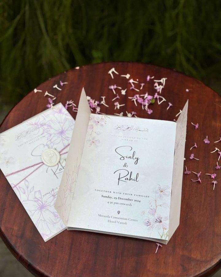 Lavender floral folded invitation from @artzee._. Wax seal and translucent panels frame elegant wedding details.