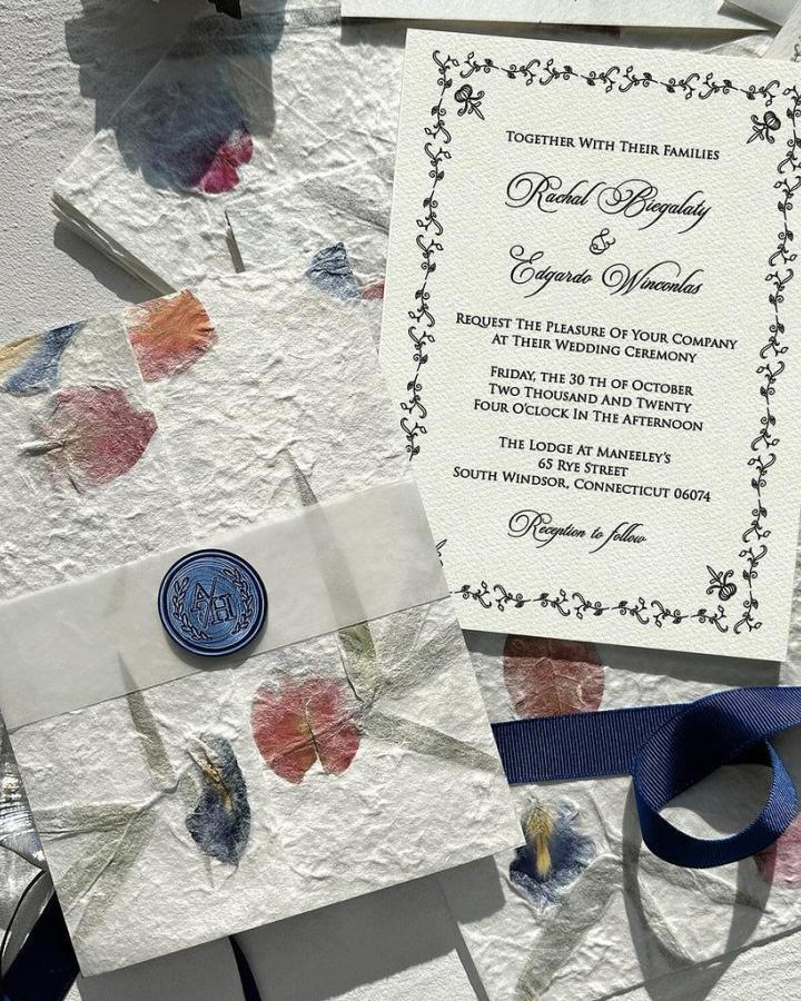 Ivory botanical handmade wedding invitations ideas from @pickybride. Deckled paper, pressed petals, navy ribbon, and wax seal.