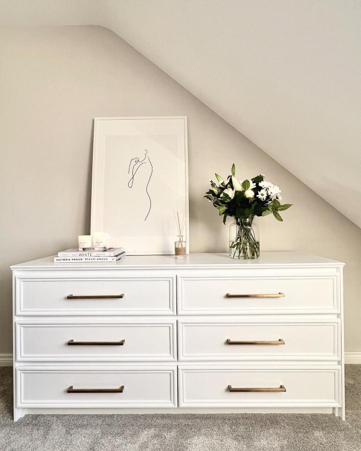White decorative-molding dresser from @home_in_ni. Brass handles sharpen this elegant Malm makeover.
