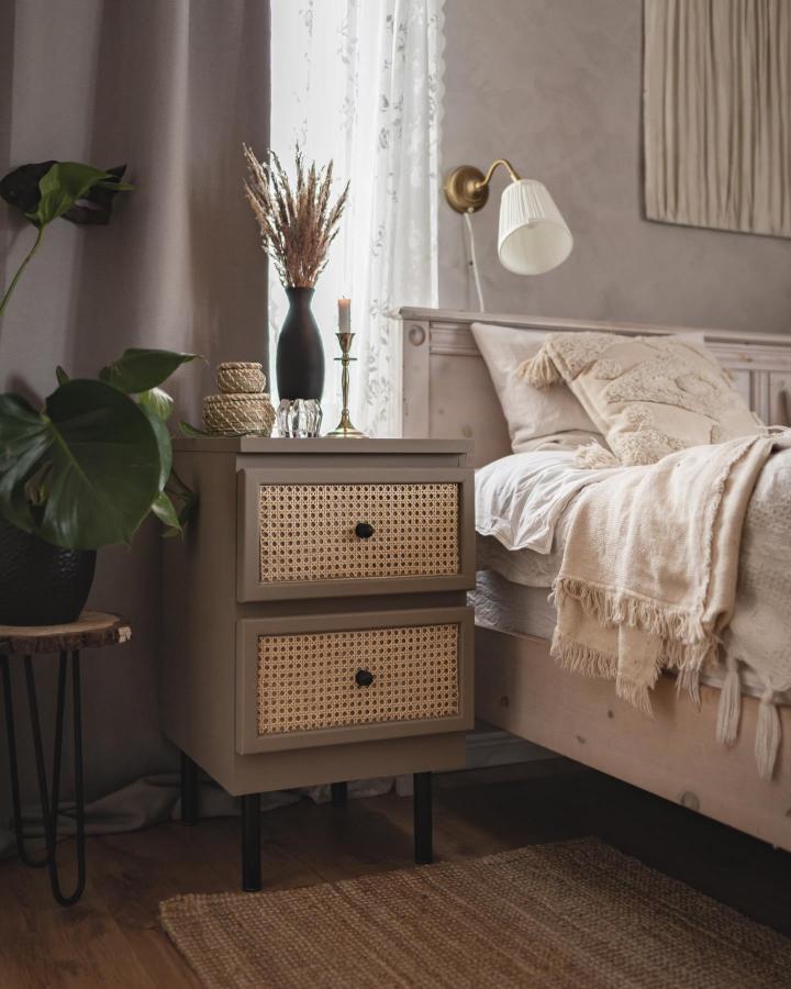 Taupe cane nightstand from @alisheinleht. Raised legs and woven drawer fronts refresh a classic bedroom piece.