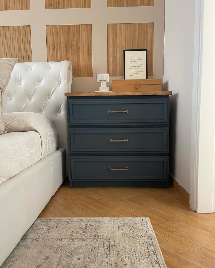 Navy blue bedroom dresser from @about_our_home_diy. Trim molding and brass handles elevate this Malm furniture hack.