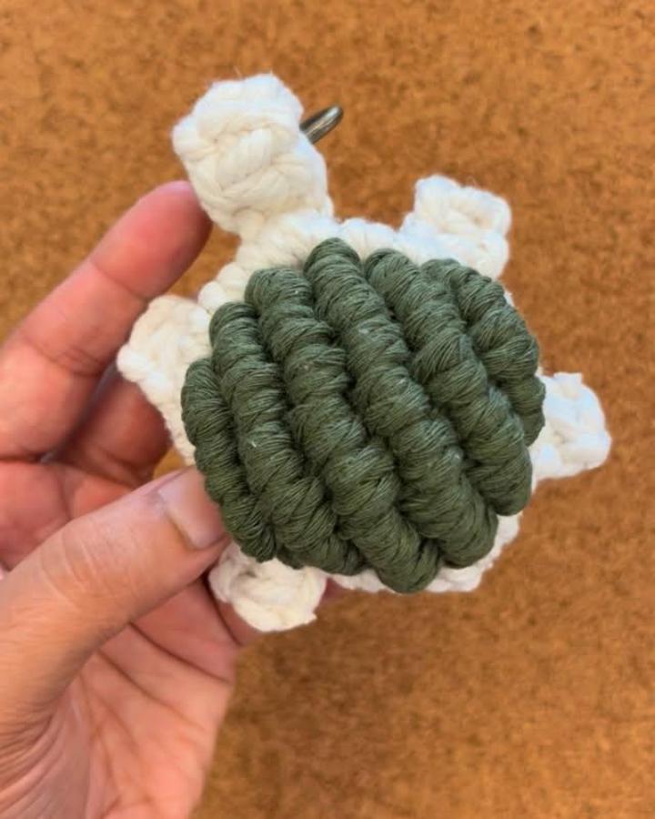 Ivory and olive-green cotton turtle charm from @craftybodhi. Chunky knots form a textured shell.