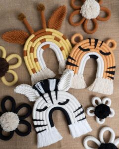 Cream, peach, and black coiled rope animal wall hangings from @kn0tty_by_nature. Playful zebra, tiger, rainbow, and floral details.
