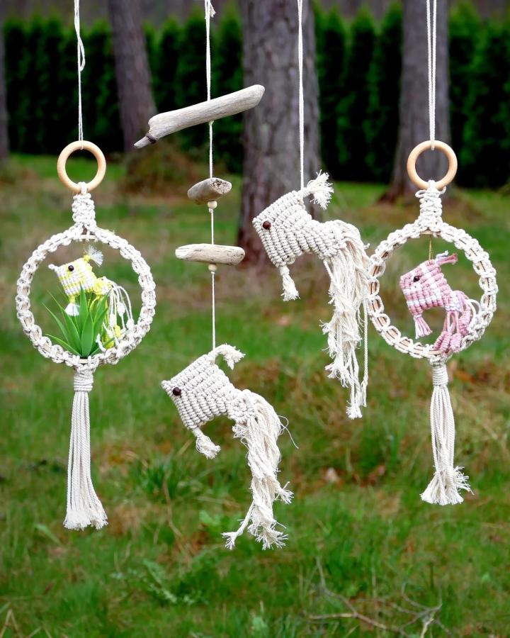 White knotted macrame animal mobiles from @macrameschool. Woodland hoops, elephants, tassels, and driftwood accents.