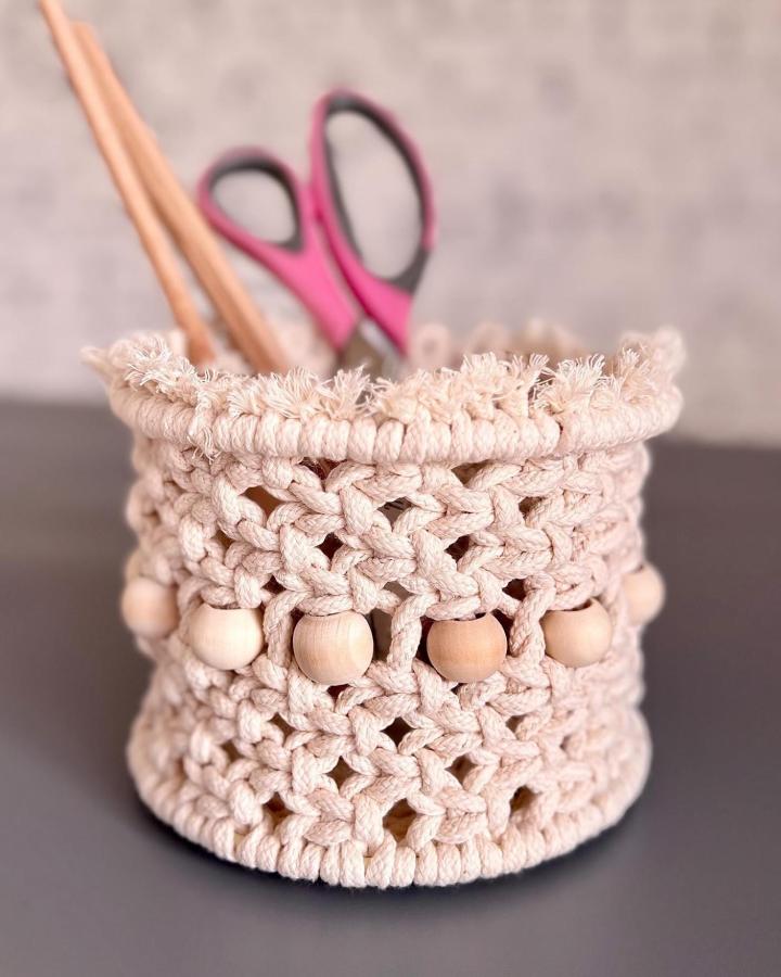 Cream knotted macrame basket from @texsense. Textured macrame basket ideas with wooden beads and fluffy fringe.