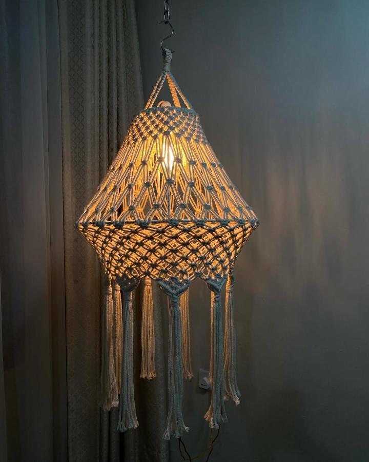 Natural beige and muted blue macrame pendant light from @boho_blossom_tz. Woven diamond shade with long tassels and warm illumination.