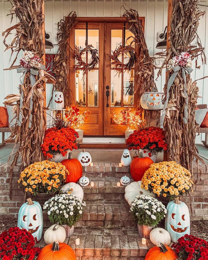 Rustic Cornstalk Entryway from @drivewaytodreams_crystal. Orange mums, pumpkins, and wreaths create a layered autumn porch.