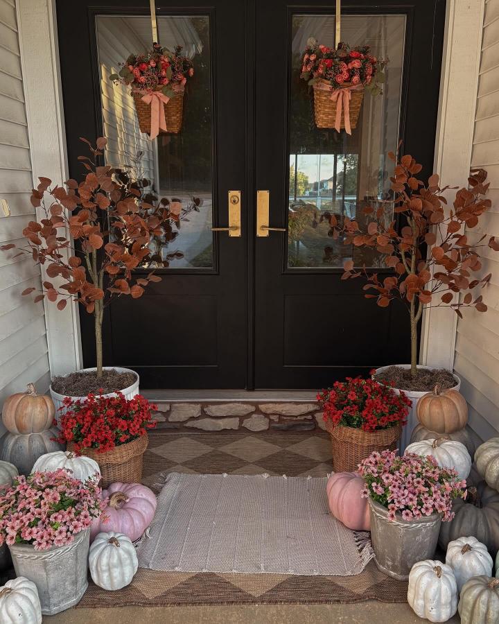 Rust-toned pumpkin planter entry from @amyphyllis_krebs. Charming small fall porch decor ideas with layered blooms.