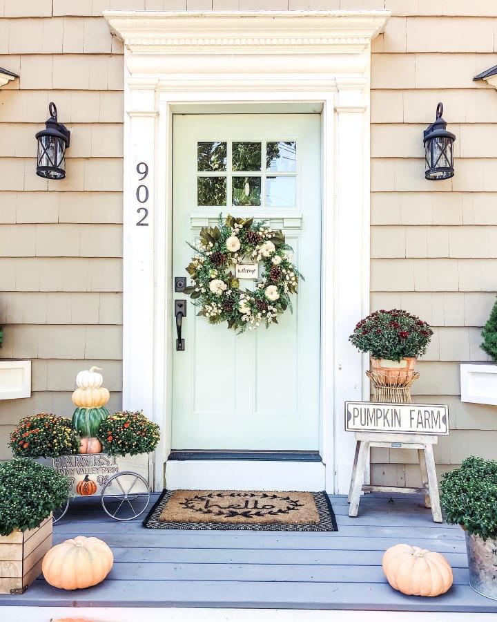 Soft sage front porch from @the_seasoned_home. Floral wreath, mums, pumpkins, and harvest sign.