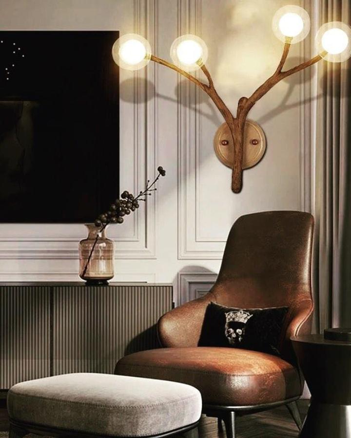 Warm brown Tree Branch Wall Light from @essentialsuppliesworld. Three glowing white bulbs brighten paneled walls.