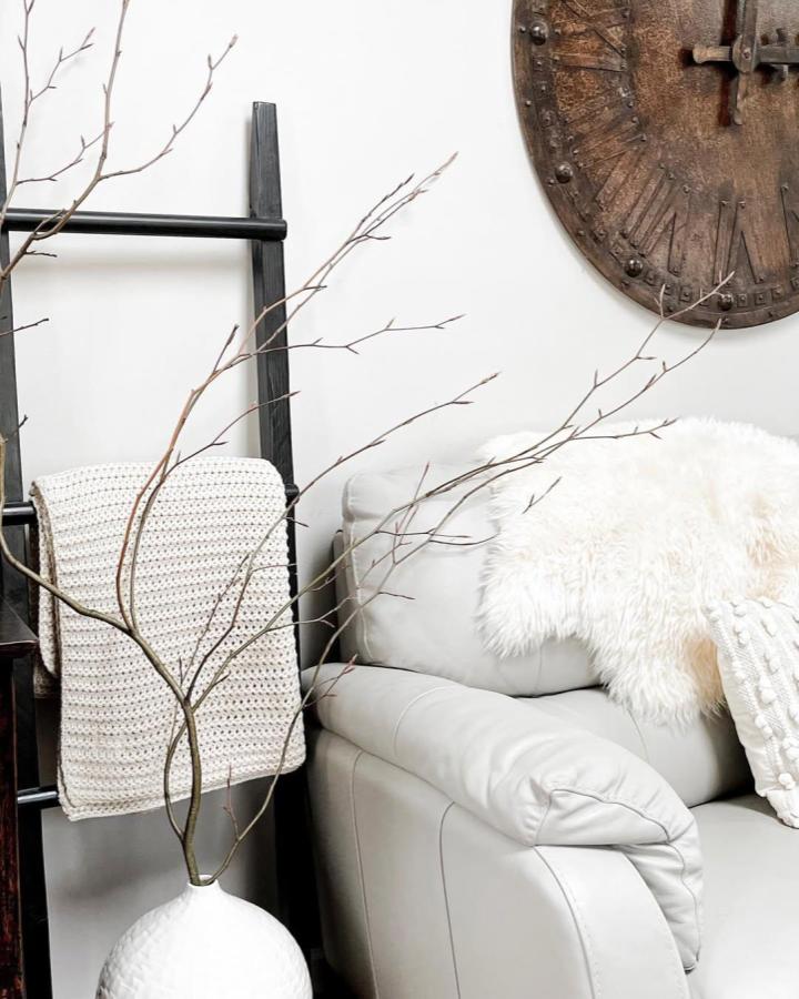 Natural brown branch arrangement in a white vase from @chroniclesofblessedhome. Cozy living room styling.
