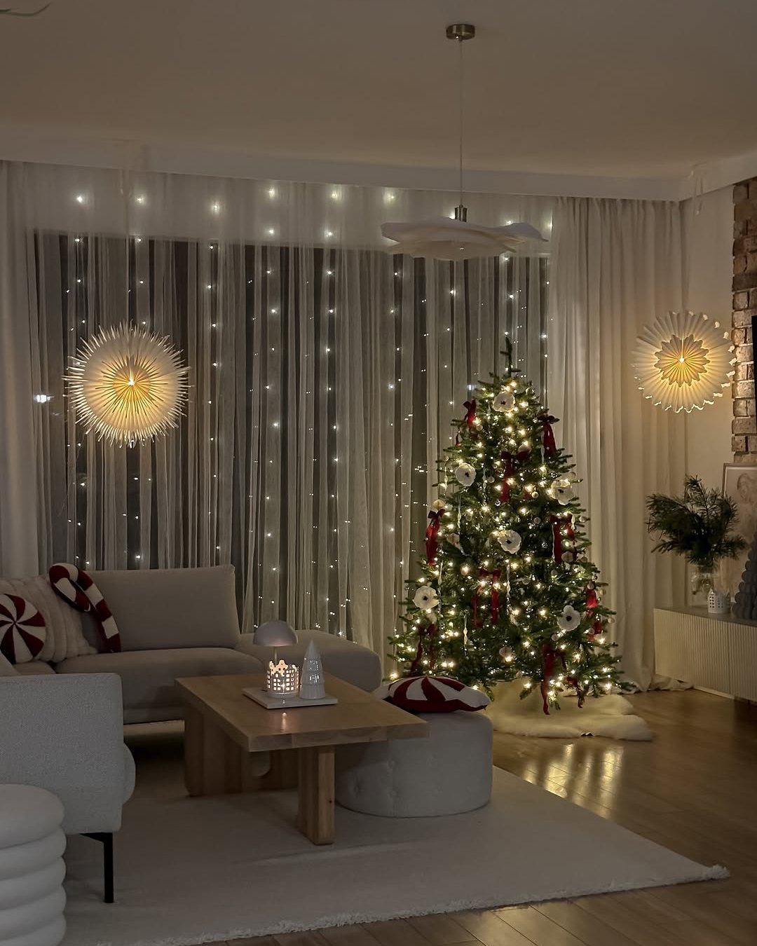 Warm window lights and a decorated tree create inviting apartment christmas decor ideas