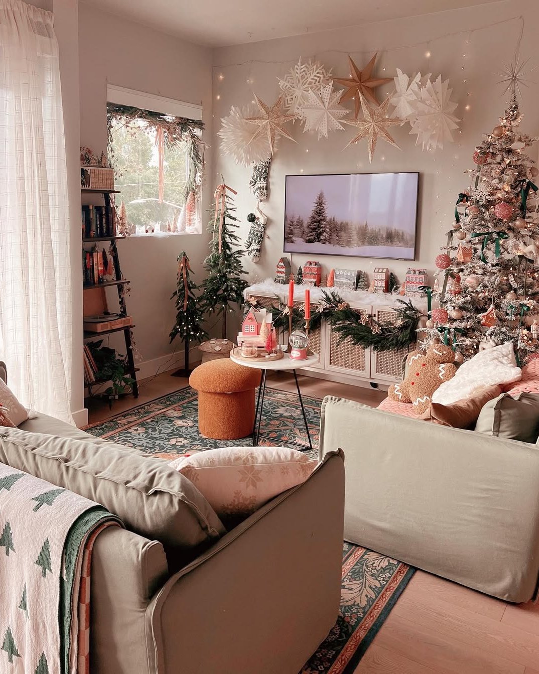 Soft apartment holiday living room with paper stars, fairy lights, flocked tree, garland, and cozy festive accents
