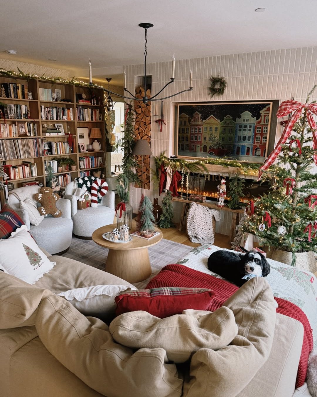Cozy apartment holiday living room with ribbon-wrapped tree, glowing garland, stockings, and layered festive textiles