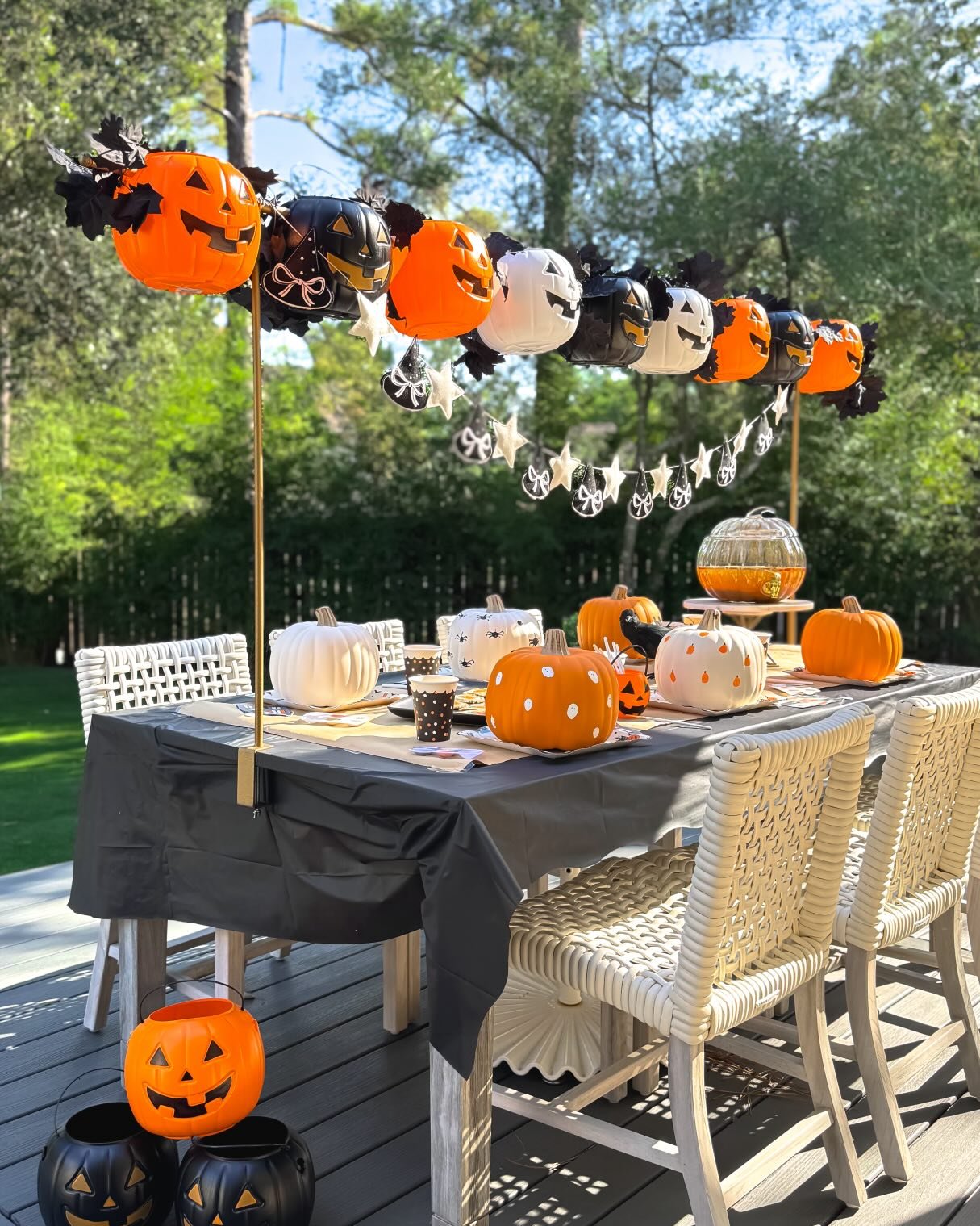 Pumpkin balloon garland and decorated table for an outdoor Halloween gathering