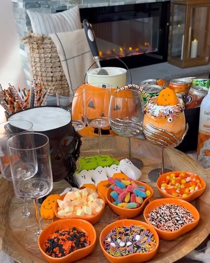 Budget Halloween table with pumpkin glasses, candy bowls, and playful drink decorations