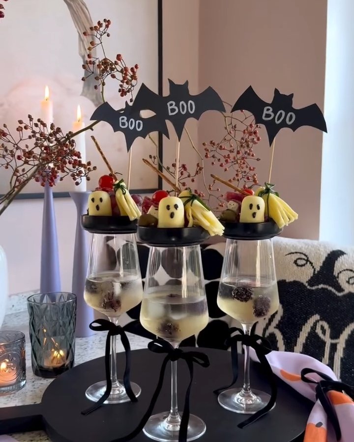 Bat drink toppers and ghost fruit glasses on a festive Halloween table