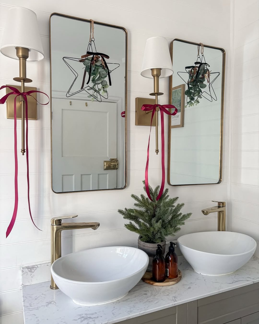 Christmas bathroom decor ideas featuring burgundy ribbons, evergreen greenery, star accents, and a bright double vanity