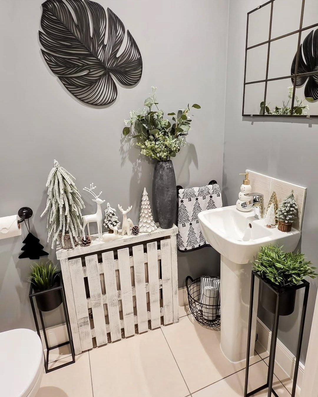 christmas bathroom decor ideas with white woodland trees, deer, greenery, and black botanical wall art
